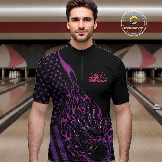 Male model at a bowling lane wearing a black bowling quarter-zip shirt with pink and purple flame bowling artwork and American flag accents.