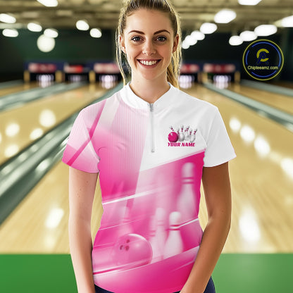 Front view female model at the bowling lane wearing a white and pink quarter zip shirt with bowling ball and pins geometric artwork.