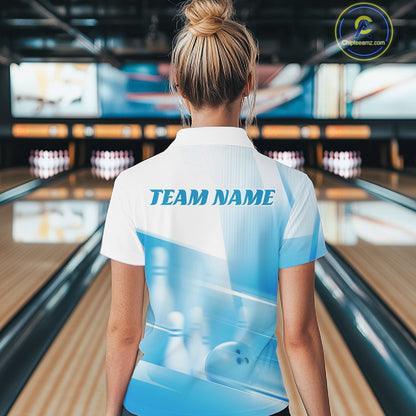 Back view of a female model in a bowling lane wearing a white and blue quarter zip shirt with bowling ball and pins over a pink geometric background.