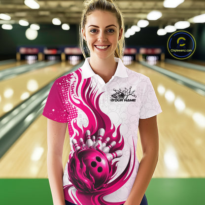 A woman stands in a bowling alley wearing a white short-sleeve polo shirt with a bold magenta and pink bowling-themed graphic print featuring a bowling ball and pins, with 'YOUR NAME' printed on the chest.