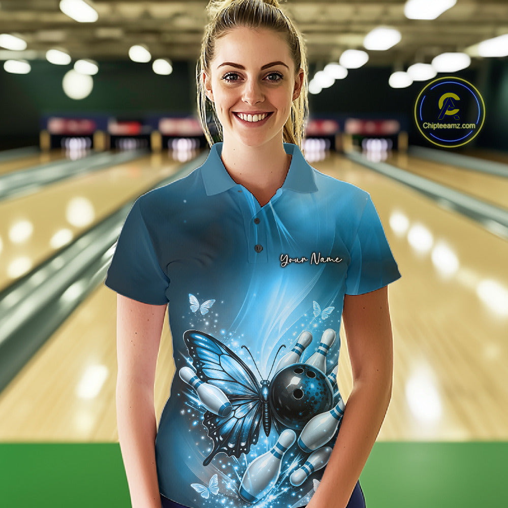Female model wearing a blue bowling polo shirt at a bowling lane with butterfly artwork, a bowling ball, and scattered pin graphics.