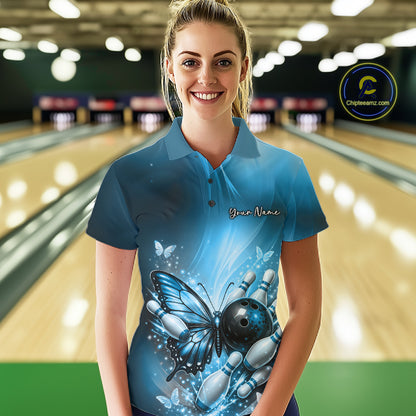 Female model wearing a blue bowling polo shirt at a bowling lane with butterfly artwork, a bowling ball, and scattered pin graphics.