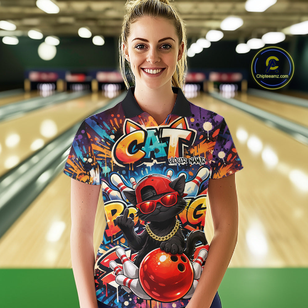 Female model wearing a colorful bowling polo shirt at a bowling lane with graffiti-style black cat artwork, sunglasses, cap, and bowling ball graphics.