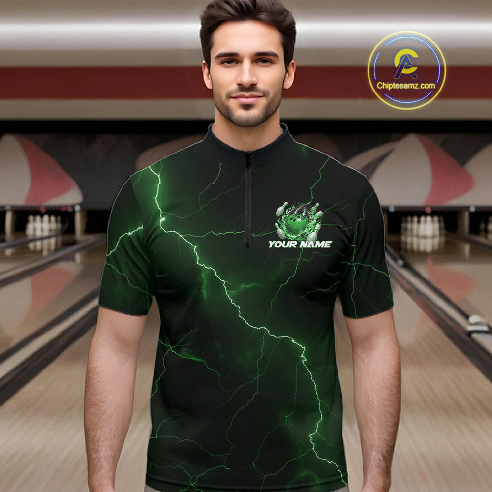 Male model at the bowling lane wearing a black and green quarter-zip with dragon claw graphics and flaming bowling ball details.