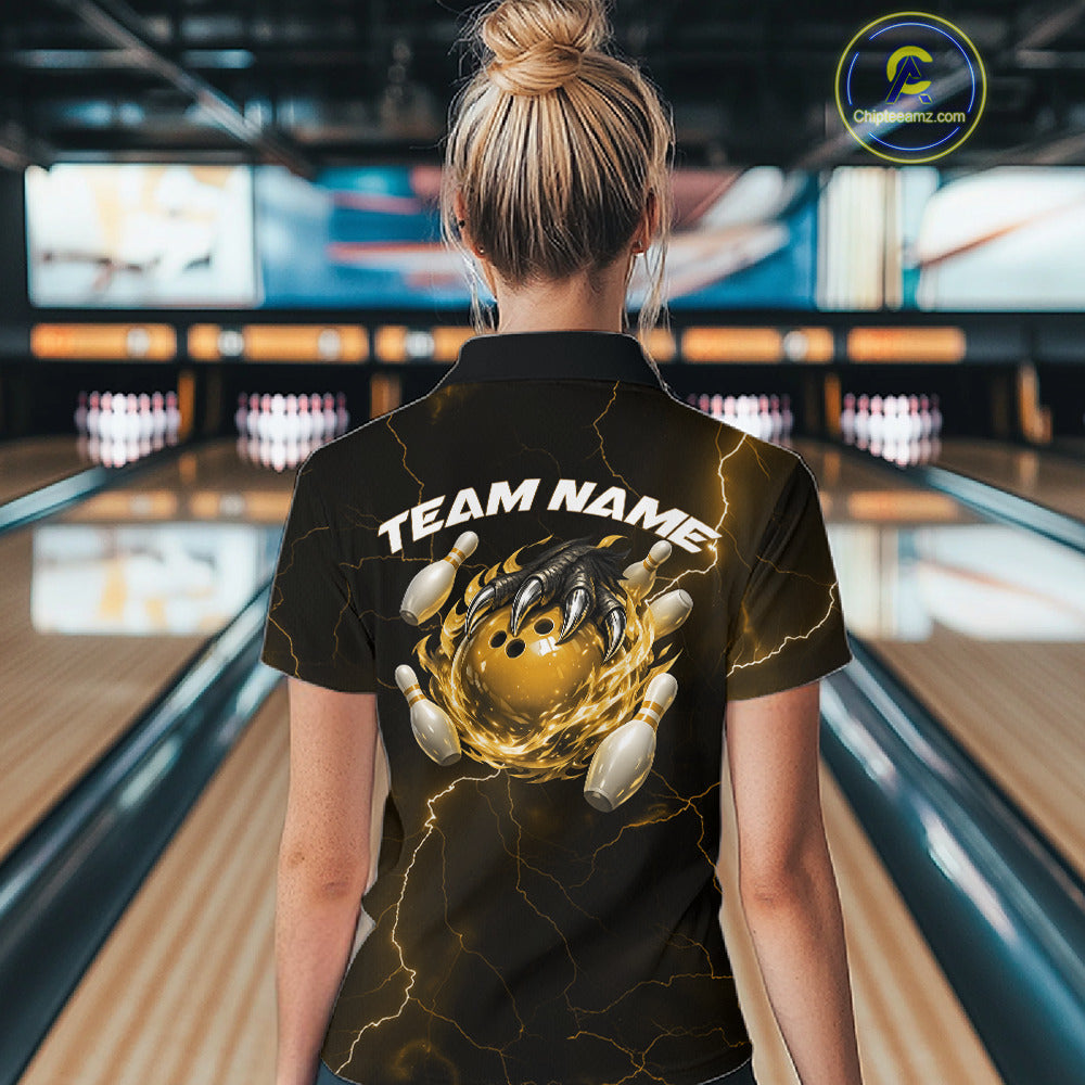 Back view of a black and yellow womens bowling polo displaying a dragon claw holding a flaming bowling ball with pin graphics.