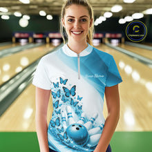 Load image into Gallery viewer, Female model wearing a white and blue bowling quarter zip with butterfly artwork and bowling-themed graphics, front view at the bowling lane