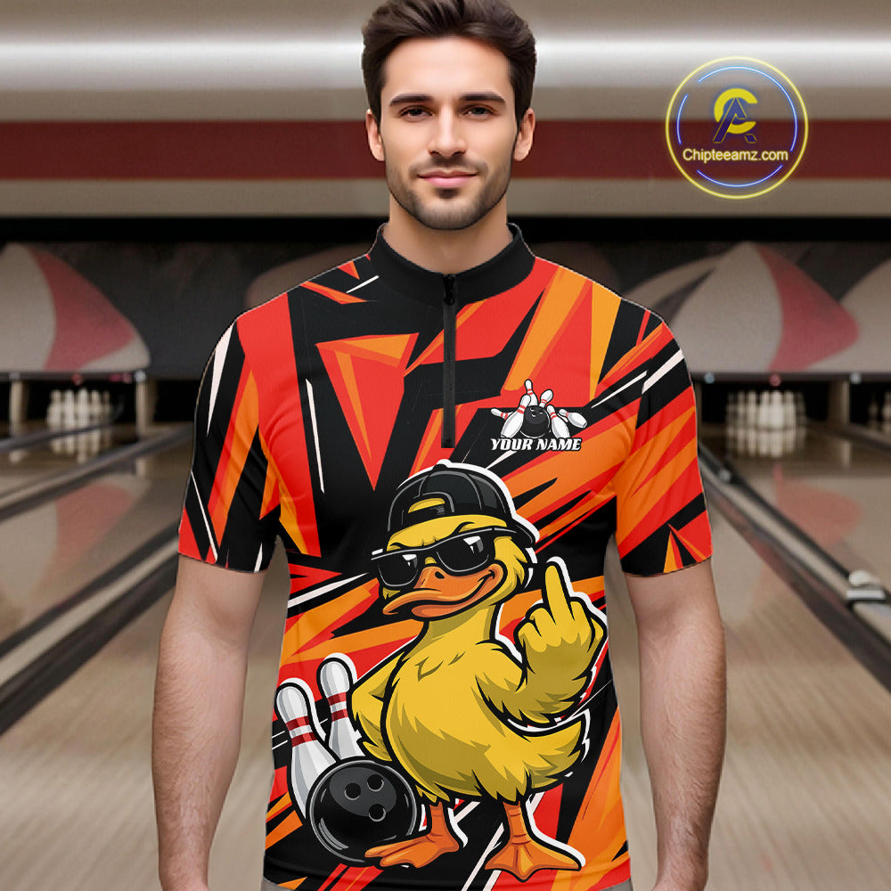 Male model at a bowling alley wearing a black and orange quarter-zip featuring a duck in sunglasses and cap beside bowling elements.