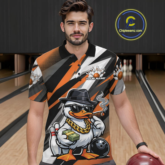 Male model wearing a black and orange bowling polo in a bowling center featuring a duck illustration beside bowling pins and ball.