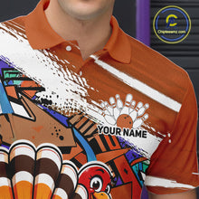 Load image into Gallery viewer, Close up front view of the left chest area on an orange custom bowling polo shirt, featuring a graffiti inspired urban street style design with paint splatter accents and a personalized name.