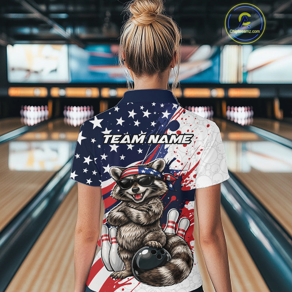 Back view female model in bowling lane wearing quarter zip shirt featuring raccoon with sunglasses and patriotic bandana leaning on a bowling ball with playful bowling graphics.