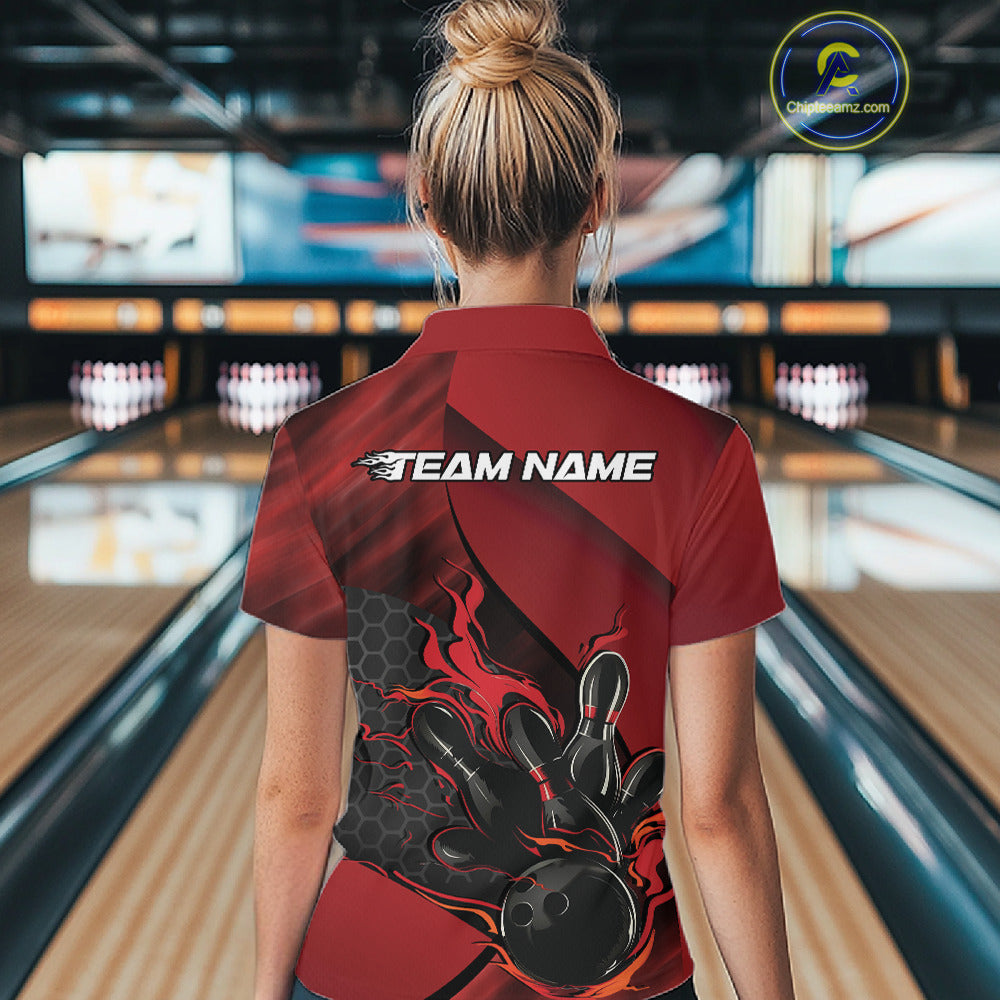 Back view of a female model in a bowling venue wearing a black and red polo shirt featuring a flaming bowling strike graphic.