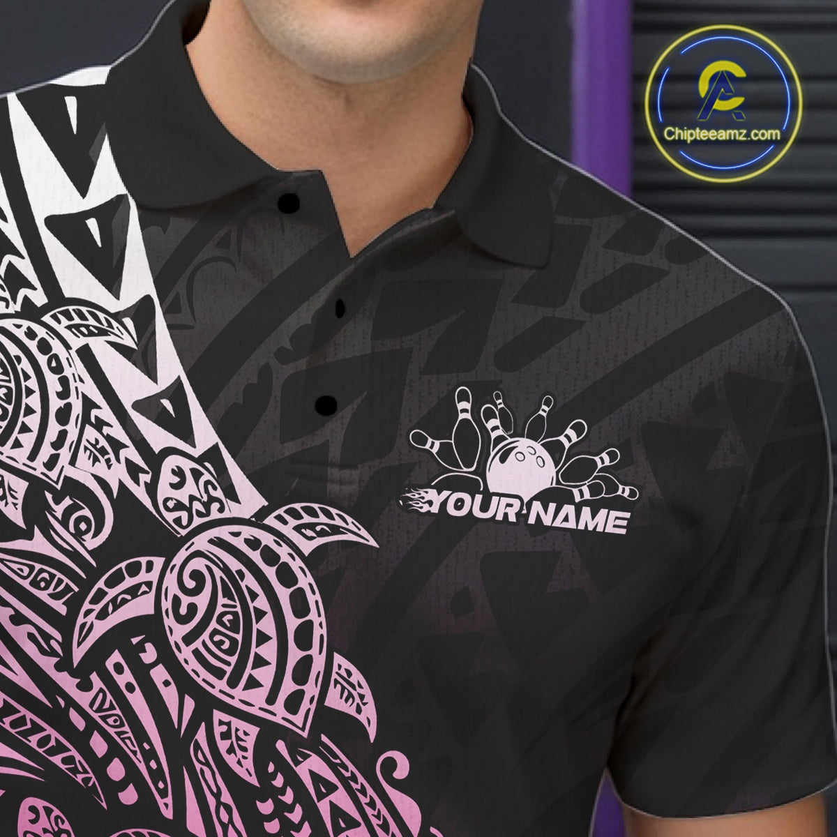 Left chest close-up of a black and pink bowling polo shirt displaying bowling artwork with Polynesian tribal details.