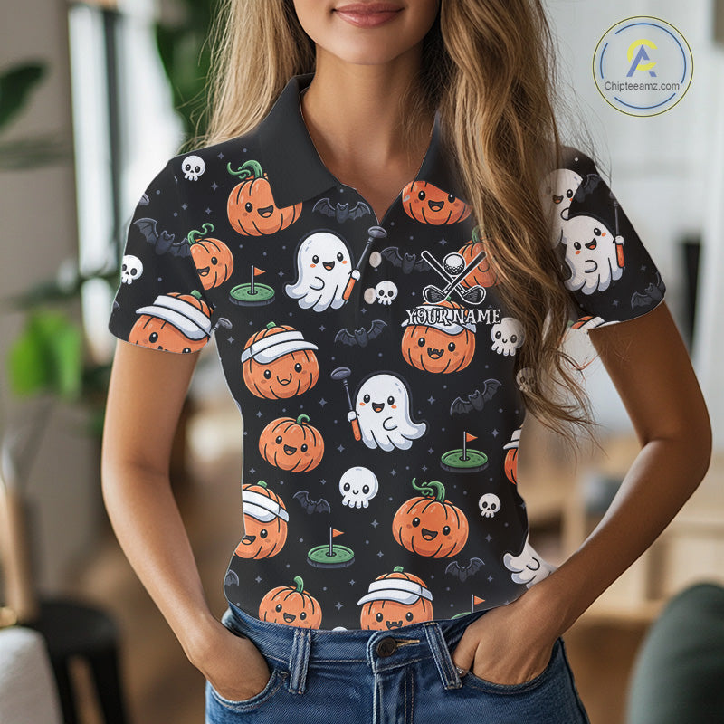A woman wearing a black short-sleeve polo shirt with a Halloween print of orange pumpkins, white ghosts, and skulls. The shirt features a custom name placeholder 'NITRONAME' and crossed golf clubs graphic.
