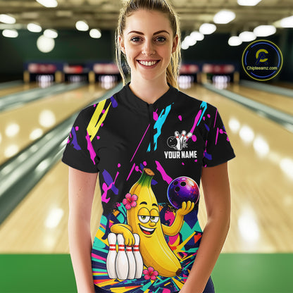 Woman wearing a colorful bowling shirt with a cartoon banana character in a bowling alley.
