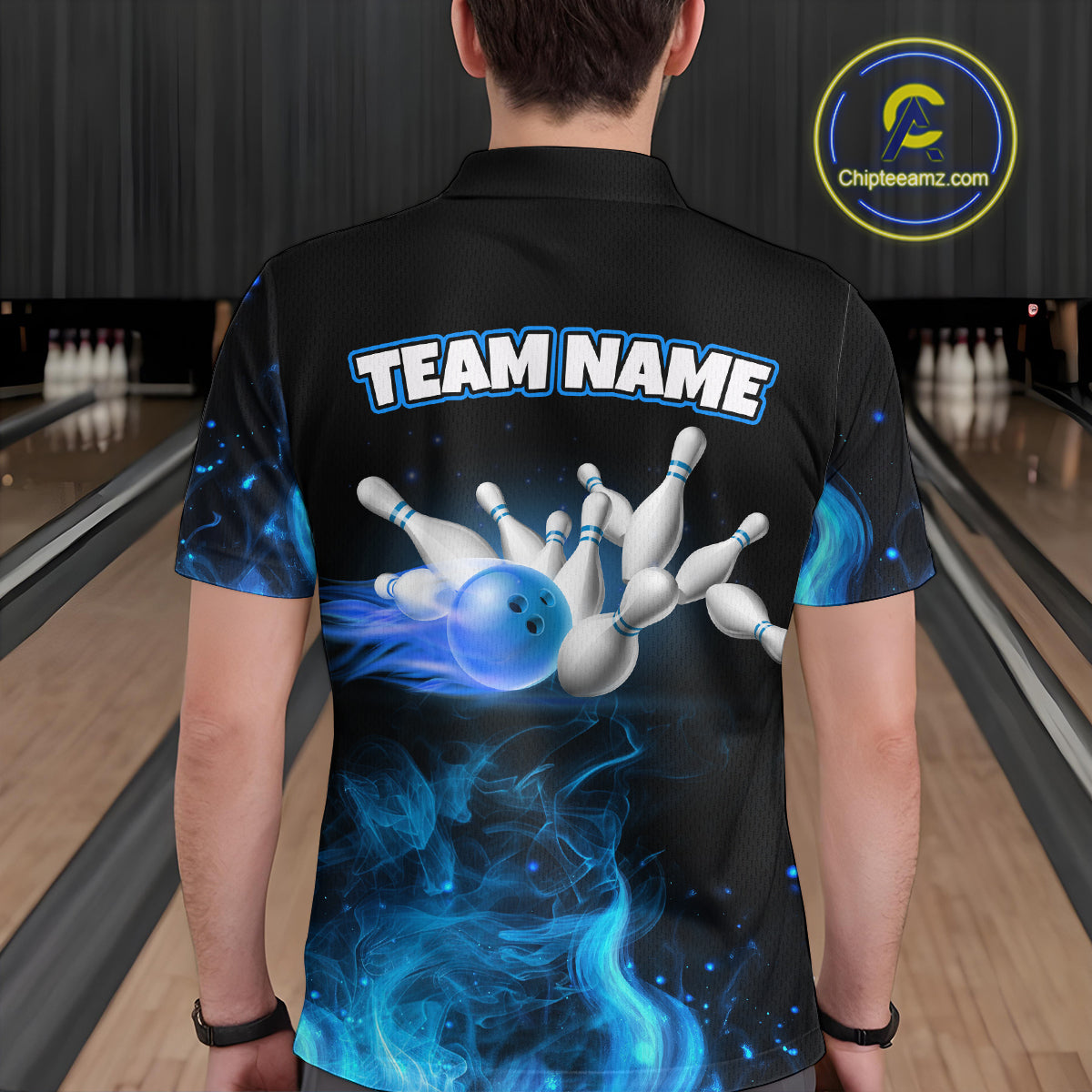 Person wearing a black bowling shirt with a blue and white design on a bowling alley.